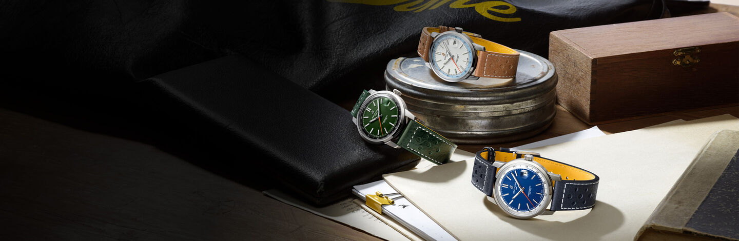 Three Breitling Top Time watches on a desk.